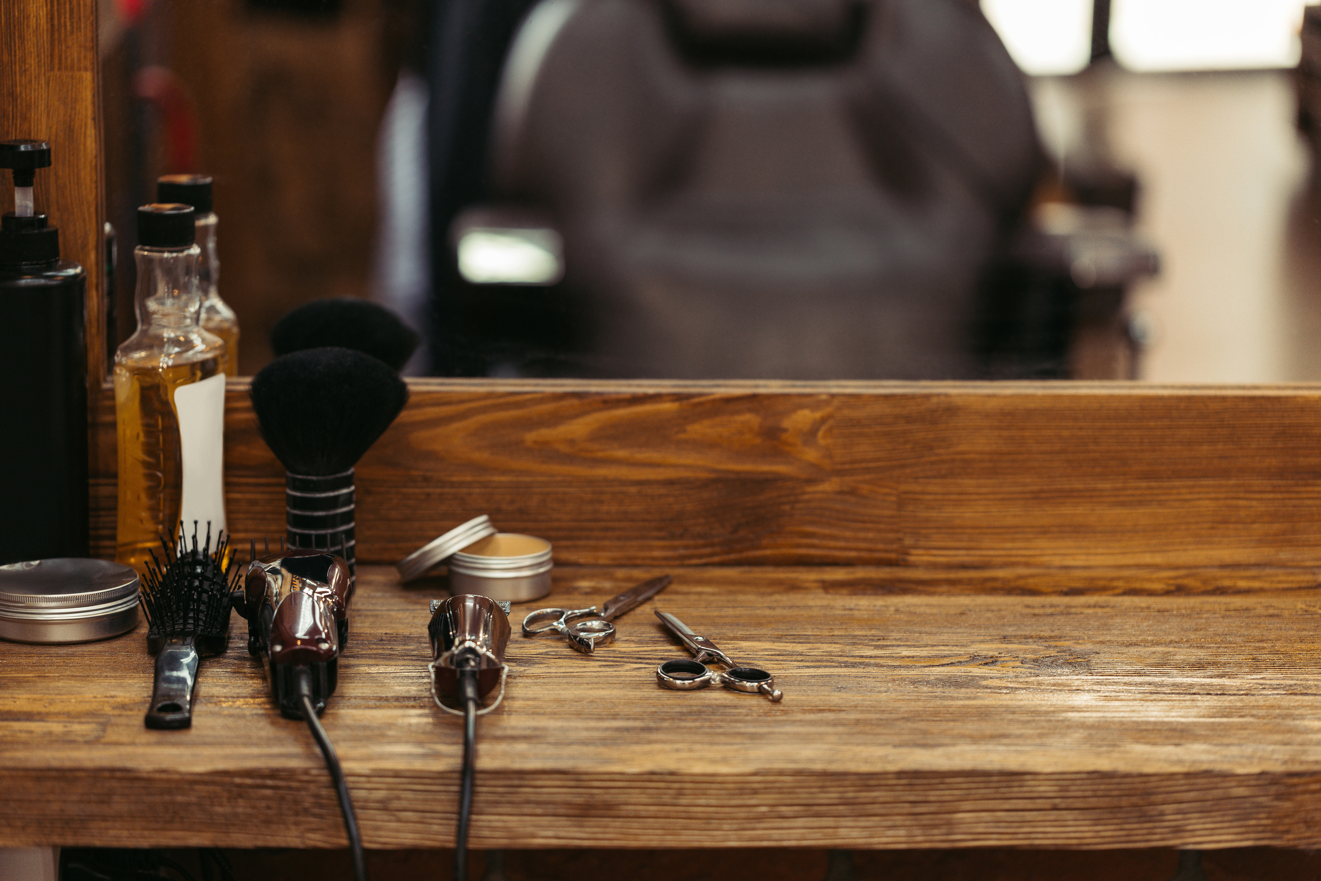 barber tools on wooden shelf and mirror in barbershop